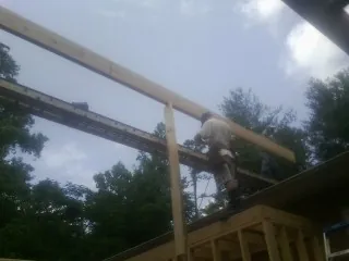 Carpenter setting a ridge beam over a new addition frame — Ice Dam Removal by Roofing Brothers in Mayer